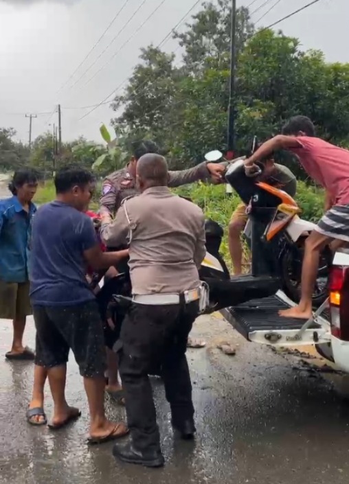 Tulus Mengabdi, Polisi Lalu Lintas Bantu Warga yang Kesulitan di Tengah Hujan