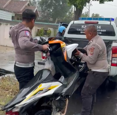 Tulus Mengabdi, Polisi Lalu Lintas Bantu Warga yang Kesulitan di Tengah Hujan